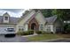 Charming home with brick entryway, attached garage, manicured lawn and lush landscaping at 1231 Creek Forest Ln, Austell, GA 30106