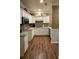 Well-lit kitchen with white cabinets, granite countertops, and hardwood floors at 1231 Creek Forest Ln, Austell, GA 30106
