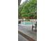 Outdoor pool area surrounded by trees, fencing and lounge chairs at 1231 Creek Forest Ln, Austell, GA 30106