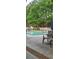 Outdoor pool area surrounded by trees, fencing and lounge chairs at 1231 Creek Forest Ln, Austell, GA 30106