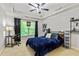 Comfortable bedroom featuring tray ceilings, a ceiling fan, and a cozy blue bedspread at 255 Ashmere Ct, Tyrone, GA 30290
