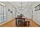 Cozy dining room featuring wainscotting, wood floors, and a chandelier over a rustic wooden table at 255 Ashmere Ct, Tyrone, GA 30290