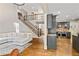 Bright open-concept living room features a staircase, hardwood floors, and a large sectional sofa at 255 Ashmere Ct, Tyrone, GA 30290