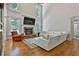 Bright living room featuring a stone fireplace, high ceilings, hardwood floors, and a comfortable sofa at 255 Ashmere Ct, Tyrone, GA 30290