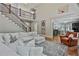 Living room featuring hardwood floors, sectional sofa, and a staircase leading to the upper level at 255 Ashmere Ct, Tyrone, GA 30290