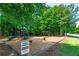 Community playground featuring play structure with slides and swing set surrounded by lush greenery at 255 Ashmere Ct, Tyrone, GA 30290