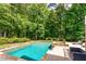 Gorgeous in-ground pool with integrated hot tub surrounded by beautiful greenery and ample seating at 255 Ashmere Ct, Tyrone, GA 30290