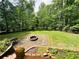 Patio with a fire pit overlooking a vast, green backyard, set against a backdrop of dense trees at 1345 Starboard Way, Cumming, GA 30041