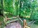 Relaxing backyard scene with lush greenery, a charming bench, and a tranquil wooded backdrop at 1345 Starboard Way, Cumming, GA 30041