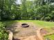 Brick patio features a built-in fire pit and grill for outdoor gatherings, surrounded by a lush lawn at 1345 Starboard Way, Cumming, GA 30041
