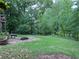 Large, grassy backyard featuring a patio area with a fire pit and space for recreation at 1345 Starboard Way, Cumming, GA 30041