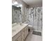 Bathroom features a dual sink vanity and a shower/tub with a floral curtain at 1345 Starboard Way, Cumming, GA 30041