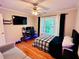 Inviting bedroom showcases a plaid comforter, computer, and tv for relaxation at 1345 Starboard Way, Cumming, GA 30041