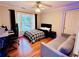 Comfortable bedroom features a plaid comforter, desk with computer, and a gray couch at 1345 Starboard Way, Cumming, GA 30041
