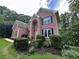 Traditional two-story brick home features a manicured lawn with mature landscaping at 1345 Starboard Way, Cumming, GA 30041