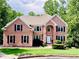 Charming two-story brick home with manicured lawn and lush landscaping at 1345 Starboard Way, Cumming, GA 30041