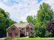 Traditional brick home with mature landscaping, offering a welcoming and stately curb appeal at 1345 Starboard Way, Cumming, GA 30041