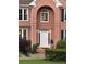 Home's inviting front entrance features arched doorway with white door and manicured landscaping at 1345 Starboard Way, Cumming, GA 30041