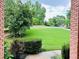 View of a meticulously landscaped front yard featuring lush green lawns and mature trees at 1345 Starboard Way, Cumming, GA 30041