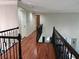 Upstairs hallway shows hardwood floors, wooden railings, and doors to various rooms at 1345 Starboard Way, Cumming, GA 30041
