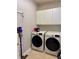 Laundry room featuring side by side washing machine and dryer and overhead cabinets at 1345 Starboard Way, Cumming, GA 30041