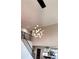 Modern chandelier hanging from high ceilings in hallway and view into kitchen at 1345 Starboard Way, Cumming, GA 30041