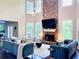 Bright living room features a stone fireplace and high ceilings with oversized windows at 1345 Starboard Way, Cumming, GA 30041