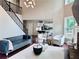 Stylish living room featuring a staircase, a sleek sofa, and a modern chandelier at 1345 Starboard Way, Cumming, GA 30041