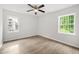 Bedroom featuring sleek flooring, a ceiling fan, and two windows providing ample natural light at 1712 Venetian Sw Dr, Atlanta, GA 30311
