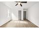 Well lit bedroom with sleek floors, ceiling fan, one window, and gray closet doors at 1712 Venetian Sw Dr, Atlanta, GA 30311
