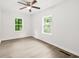 Bright bedroom featuring sleek flooring, a ceiling fan, and two windows providing natural light at 1712 Venetian Sw Dr, Atlanta, GA 30311