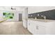Eat-in kitchen featuring granite countertops, modern backsplash, and an adjacent open-concept living area at 1712 Venetian Sw Dr, Atlanta, GA 30311