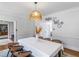 Well-lit dining room with seating for six, featuring custom light fixture, hardwood floors and decorative wall plates at 2270 Emerald Dr, Jonesboro, GA 30236