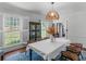 Bright dining room features a large window with custom shutters, a modern light fixture, and seating for six at 2270 Emerald Dr, Jonesboro, GA 30236