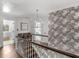 Second-floor hallway with wood flooring, custom wallpaper, a modern light fixture, and access to multiple rooms at 2270 Emerald Dr, Jonesboro, GA 30236