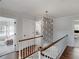 Elegant hallway with wood flooring, a statement light fixture, decorative wallpaper and access to multiple rooms at 2270 Emerald Dr, Jonesboro, GA 30236