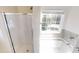Bathroom featuring a shower with glass door, white bathtub with window view and neutral tiled walls at 4884 Antelope Cv, Atlanta, GA 30349