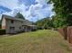 Expansive green backyard featuring privacy fence, deck, swing set, and mature trees at 639 Royal Abbey Dr, Stone Mountain, GA 30088
