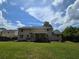 Large backyard featuring a deck, green grass, swing set, and mature trees at 639 Royal Abbey Dr, Stone Mountain, GA 30088