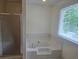Bright bathroom featuring an enclosed tub and a sliding shower door by a window at 639 Royal Abbey Dr, Stone Mountain, GA 30088
