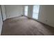 Spacious bedroom with neutral carpeting and bright windows featuring wood blinds at 639 Royal Abbey Dr, Stone Mountain, GA 30088