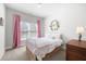 Bright bedroom with a full bed, pink curtains, carpeted floor, and decorative elements at 217 Napa Dr, Woodstock, GA 30188