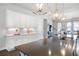 Bright kitchen with white cabinets, modern lighting, stainless sink, and an island with dark countertop at 217 Napa Dr, Woodstock, GA 30188