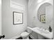 Tastefully decorated powder room featuring modern fixtures, framed art, and a pedestal sink at 217 Napa Dr, Woodstock, GA 30188