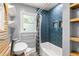 Bathroom with blue herringbone tile shower, wood shelves, and modern sink at 2274 Edgemore Se Dr, Atlanta, GA 30316