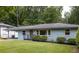 Cozy house with a light blue painted brick facade, covered parking, and lush green lawn at 2274 Edgemore Se Dr, Atlanta, GA 30316