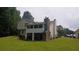 Backyard featuring a screened-in porch, a brick chimney, and a spacious lawn at 2477 Briar Valley Way, Dacula, GA 30019
