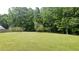 Vast backyard with a soccer net and lush green lawn surrounded by mature trees at 2477 Briar Valley Way, Dacula, GA 30019