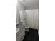 Bathroom with black floors, modern cabinet, and shower with curtain and storage for an efficient design at 2477 Briar Valley Way, Dacula, GA 30019