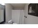 A well-lit bathroom featuring a shower with a white curtain, toilet, and a framed tiger picture at 2477 Briar Valley Way, Dacula, GA 30019